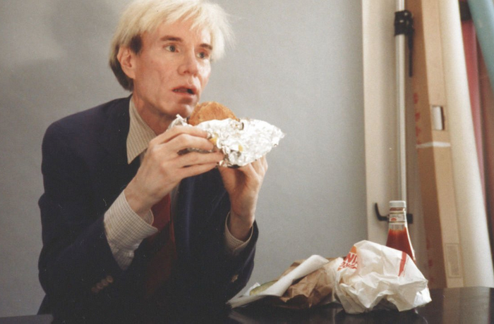 Andy Warhol eating a cheeseburger